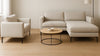 Scandinavian-style living room with two sofas of different sizes shown side-by-side under natural daylight, highlighting scale and material details for a buying guide.