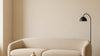 Hero image: A low-profile, rounded sculptural sofa in a softly lit living room, styled at room scale with realistic upholstery texture and proportions.