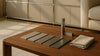 Editorial living room scene highlighting a USM-style modular metal storage system with finish samples for a pre-purchase comparison, photographed with realistic materials and lighting.