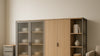 Editorial living room featuring a modular storage cabinet and a slim rolling drawer unit, highlighting materials, scale, and practical organization.